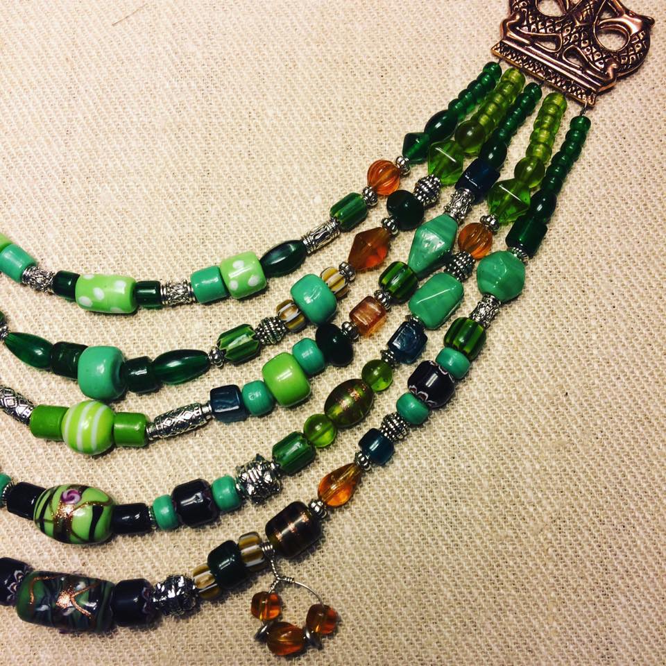 Vikingainspirerat halsband med gröna och bärnstonsfärgade glaspärlor, kombinerat med metallbeslag.