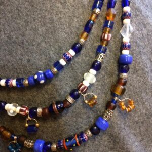 Vikingainspirerat pärlhalsband med blå glaspärlor, metallbeslag och dekorativa pärlspridare.