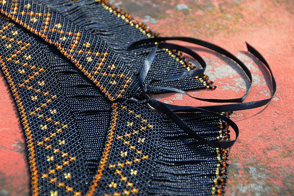 Handgjord pärlad väska eller textil med geometriskt mönster i svart och guld